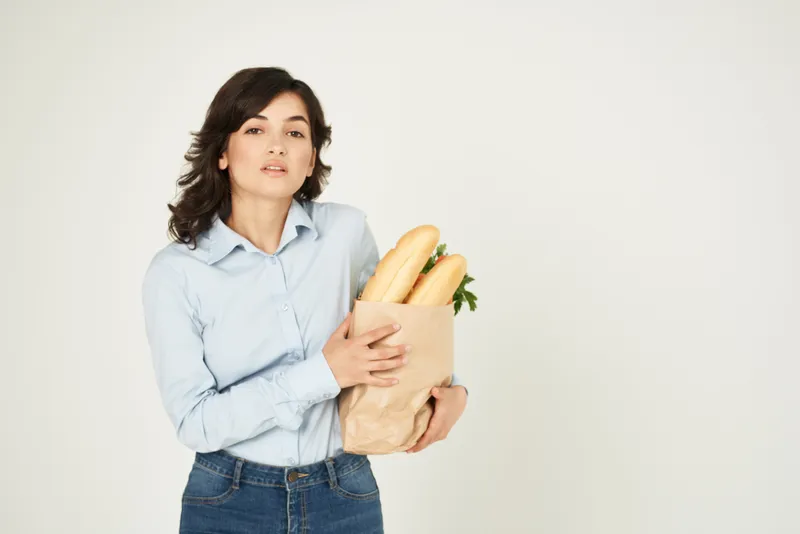 Милый брюнетка с продуктами в супермаркете, совершает покупки для диетического питания