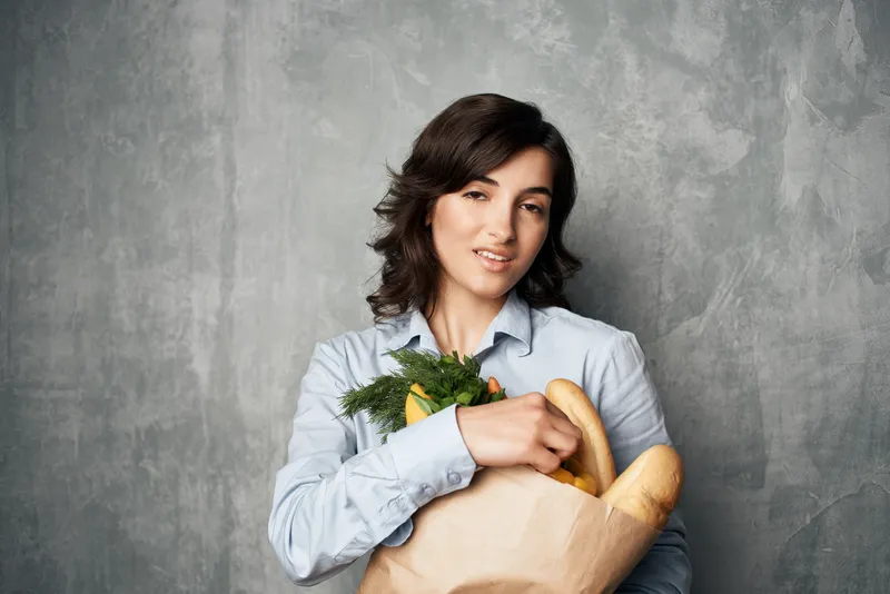 Женщина с пакетом продуктов в супермаркете, здоровая пища