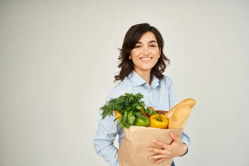 Симпатичная брюнетка с пакетом органических продуктов, овощей, для здоровья