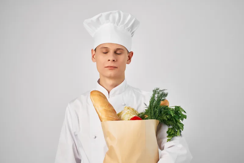 Шеф-повар занимается приготовлением еды, используя упаковку с продуктами