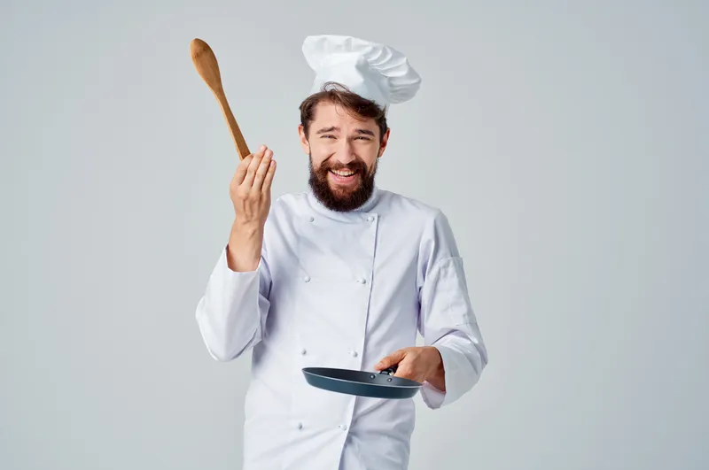 Повар работает с кухонной утварью на кухне ресторана