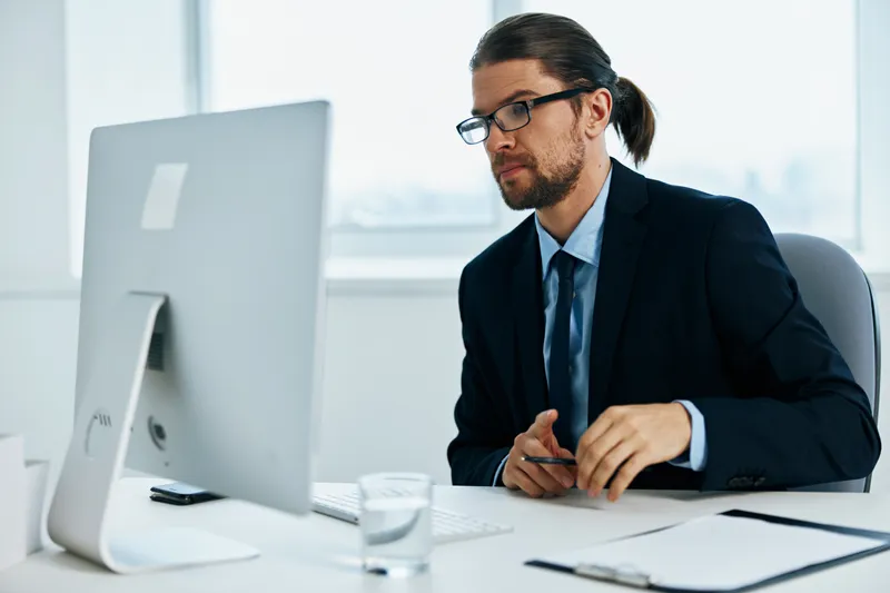 Мужчина в костюме, официальное лицо, работает за компьютером