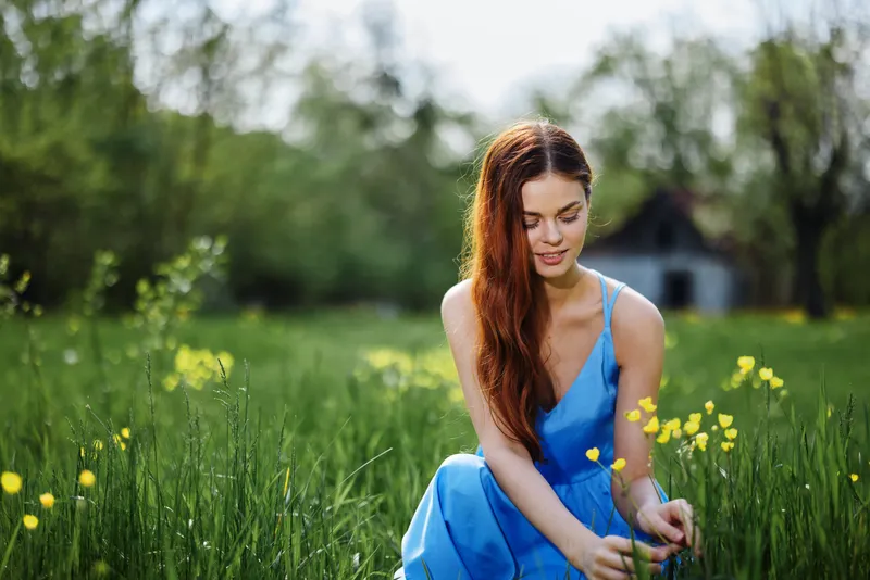 Женщина весной на природе улыбается, обнажая зубы