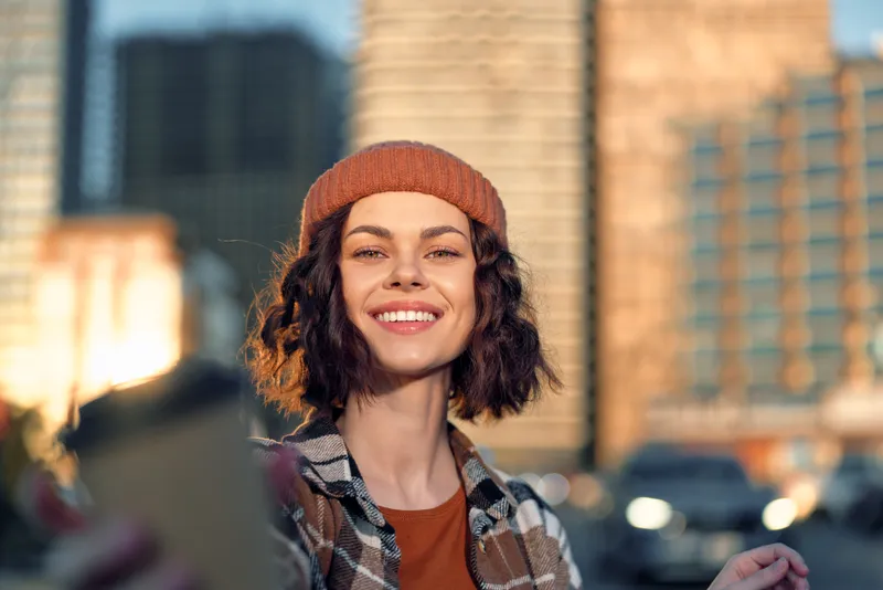 Woman smile portrait urban selfie in golden hour glow, candid lifestyle moment with authenticity and emotional storytelling, mindful living mood on modern city street.