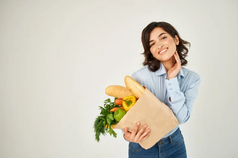 Милый брюнетка с продуктовой сумкой, полной здоровой еды, в супермаркете, обслуживание