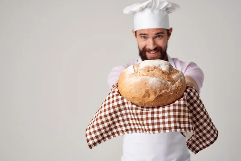 Мужчина в белом фартуке занимается изысканной кулинарией и выпечкой в ресторане