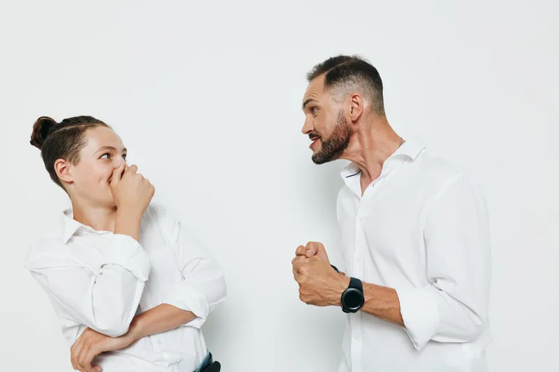 Professional man and colleague engage on a clean isolated background, conveying business intensity and emotion through expressive dialogue and confident body language.