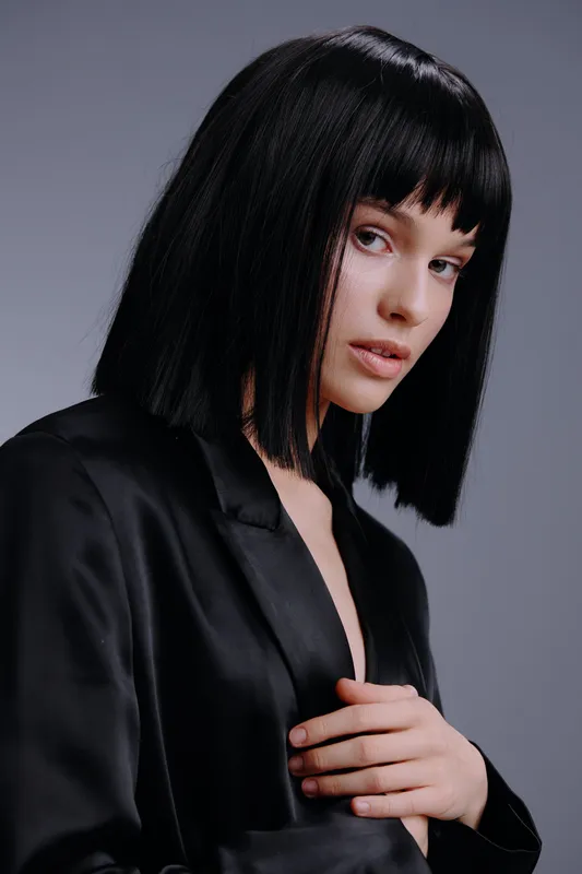 Черный костюм, женщина, черный парик-каре, серый фон