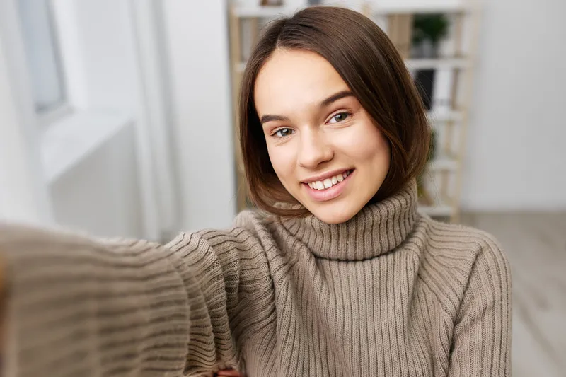 Женщина делает селфи на смартфон дома