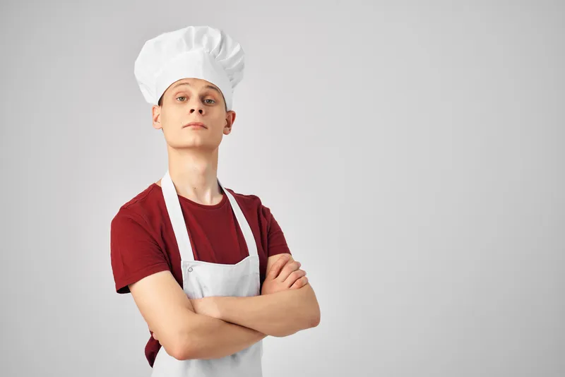 Мужчина в фартуке профессионально работает на кухне