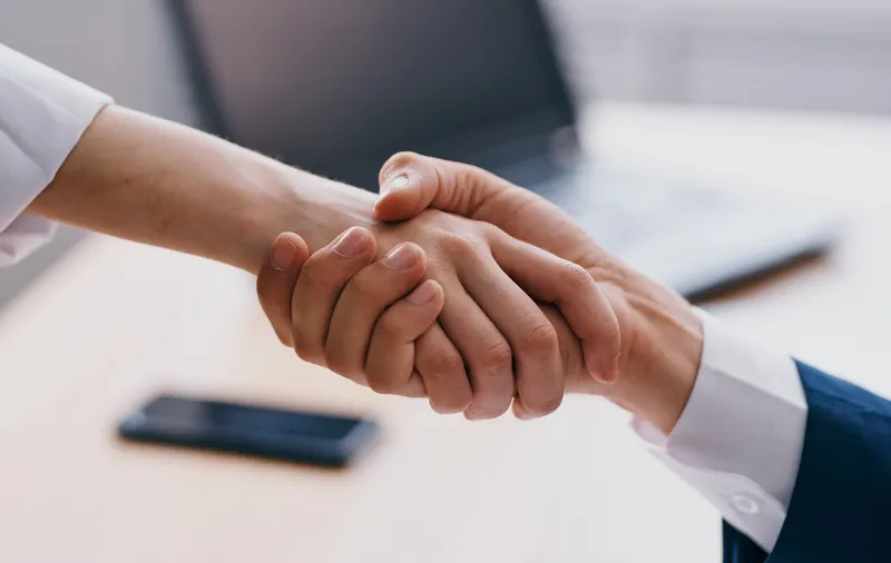 Деловые люди пожимают друг другу руки на работе в офисе, демонстрируя взаимопонимание