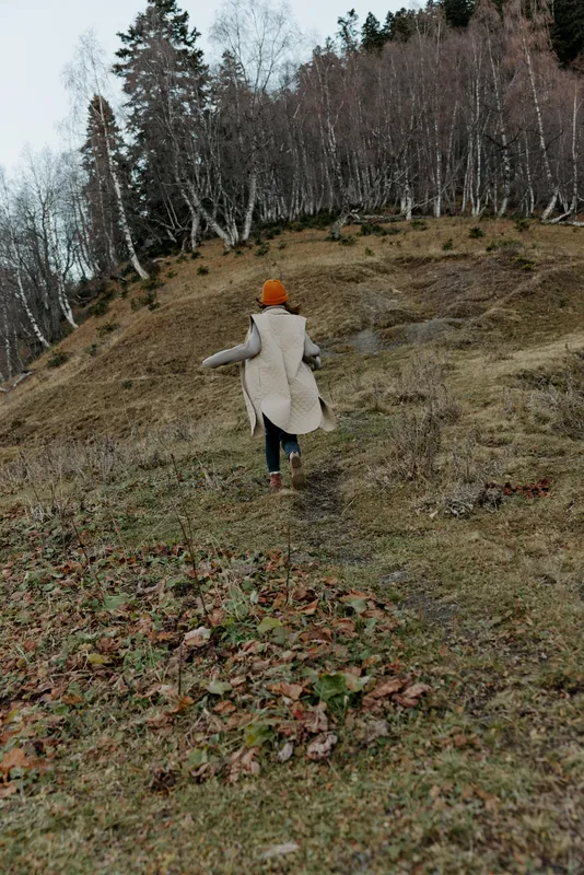 Молодая женщина в осенней одежде среди деревьев, путешествует и отдыхает на природе