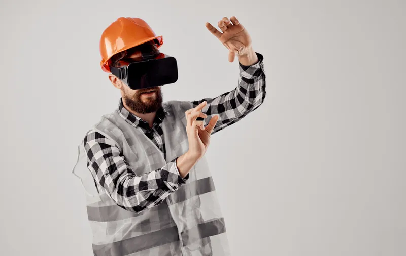 Инженер-строитель в 3D-очках виртуальной реальности и оранжевой каске на голове