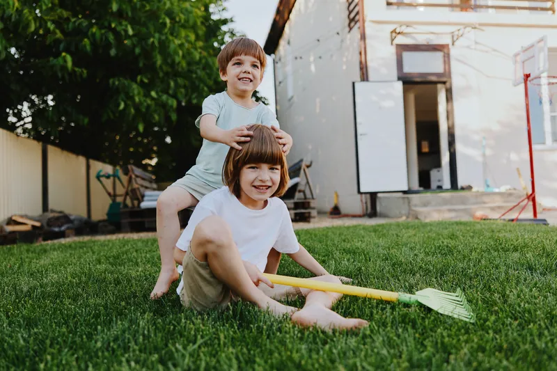 Happy children playing in a backyard, enjoying summer activities with toys and laughter. A joyful moment full of childhood innocence and fun.