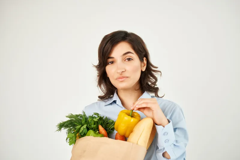 Брюнетка с пакетом продуктов, органическая еда, супермаркет