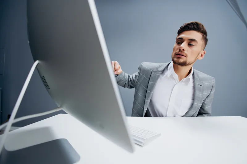 Красивый мужчина работает за компьютером в офисе, технологии