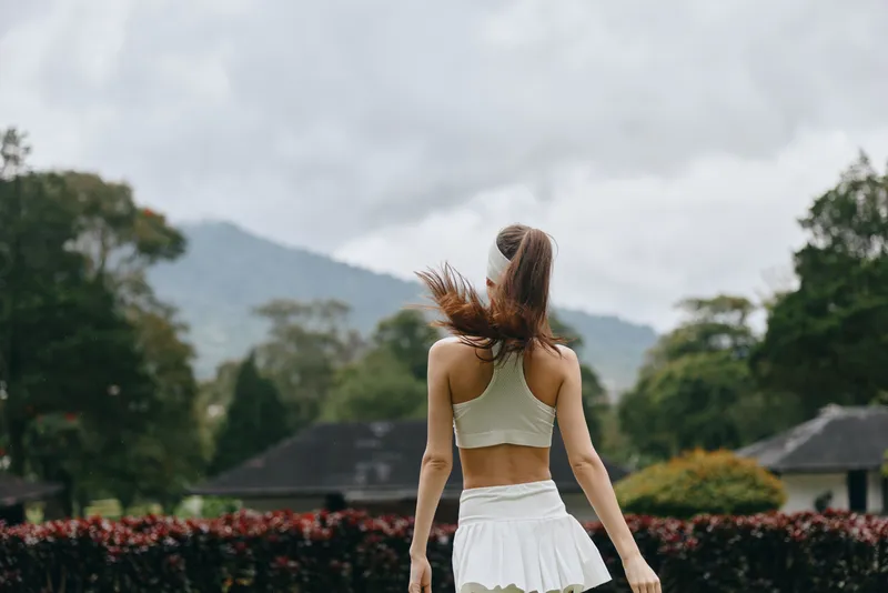 A young female model in sportswear enjoying nature with a scenic backdrop, embodying a sense of freedom and health, ideal for fitness related content