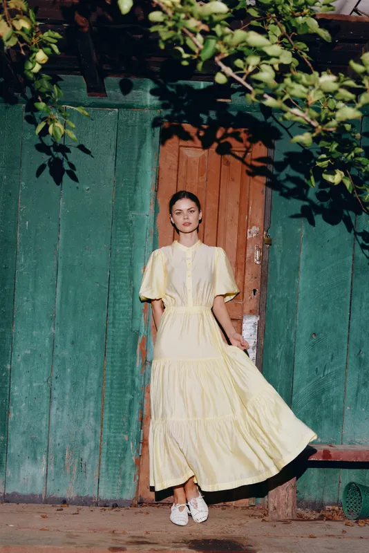 woman dress vintage doorway authenticity inclusivity, yellow maxi dress portrait leaning against green wooden door in warm sunlight