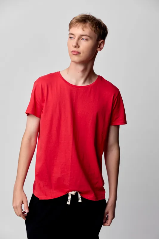 Red shirt, male model, casual wear, studio shot, fashion, young adult, relaxed pose, everyday clothing, minimal styling, bright backdrop, clean aesthetic for stock use