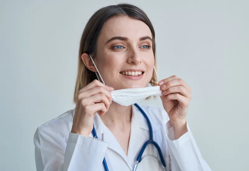 Врач в медицинской маске и халате, ведущий здоровый образ жизни, со стетоскопом