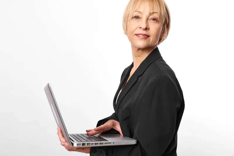 woman business laptop portrait senior confident office technology communication, professional female manager in black blazer holds open laptop, smiling in studio white background