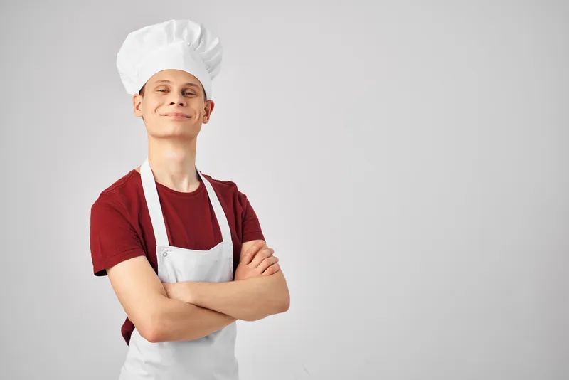 Мужчина в фартуке на кухне на светлом фоне, профессиональный повар