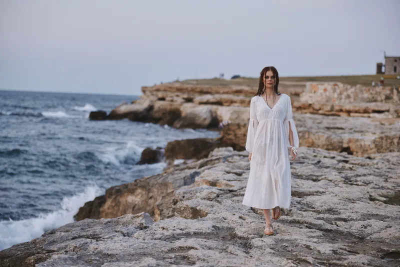 Женщина-путешественница идет по вулканическим скальным образованиям на острове, отдыхает