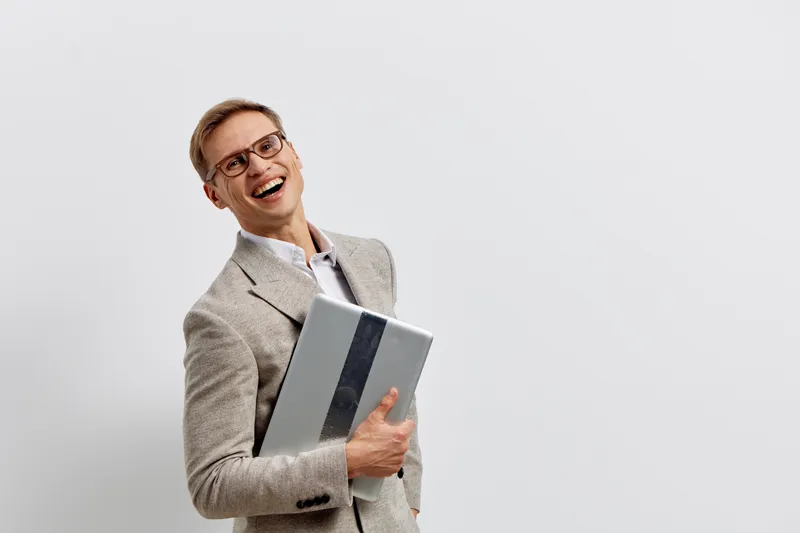 Smiling woman dressed in business attire holding a tablet device, looking cheerful and confident. Studio portrait with plain white background, professional and modern appearance, lifestyle concept, wo
