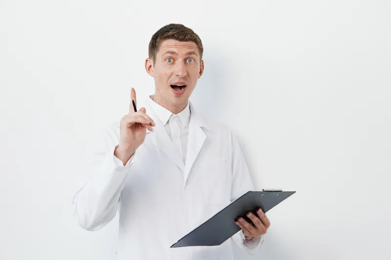 Мужчина-врач в белом халате, молодой и здоровый, смотрит на вас