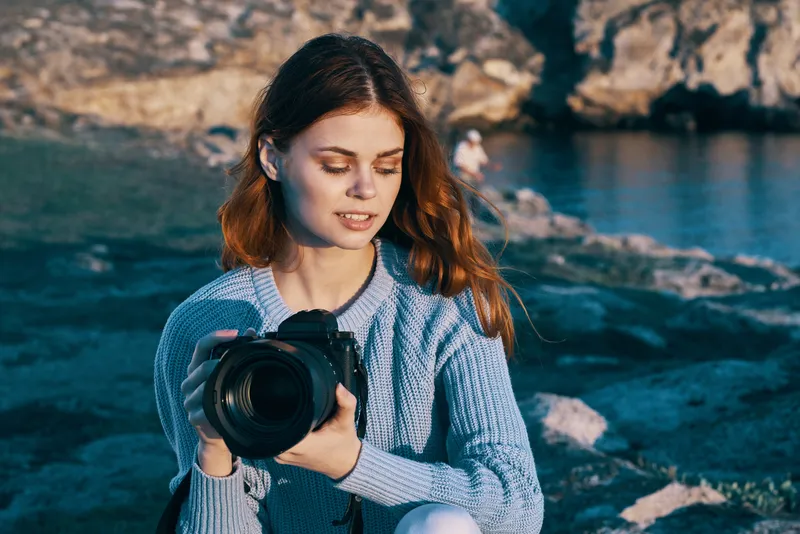 Красивая женщина-фотограф путешествует по живописному ландшафту с камерой