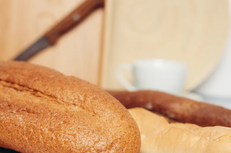 Буханка хлеба, разделочная доска, ложки, кухня, завтрак