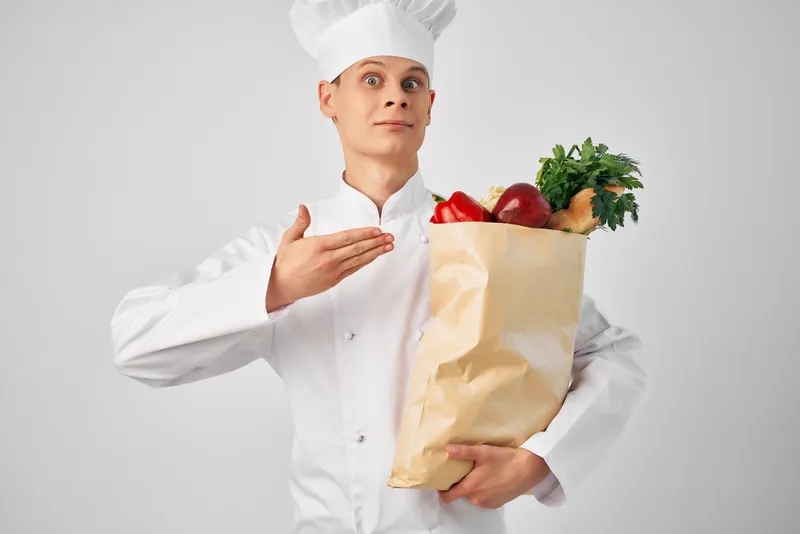Шеф-повар-мужчина с упаковкой продуктов для здорового питания на кухне