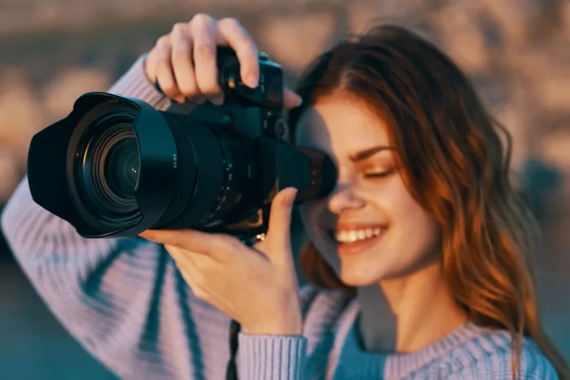 Счастливая женщина-фотограф на открытом воздухе в горах, профессиональная модель на фоне пейзажа