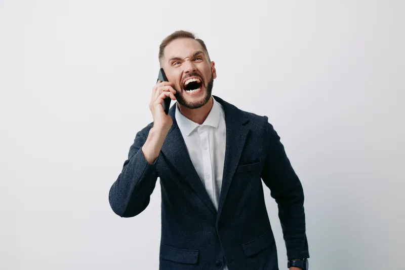 A professional business man on a call, displaying intense emotion with an energetic posture against an isolated colorful background, ready to make bold decisions and lead.
