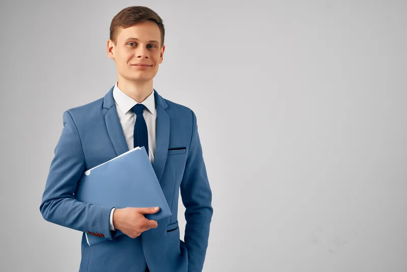 Менеджер в деловом костюме работает в офисе с документами, излучая уверенность в себе