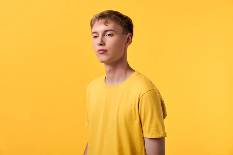 Yellow themed studio shot of a male in a yellow tee, clean background, soft lighting, minimal composition, suitable for fashion, lifestyle and product showcase, with calm confident expression