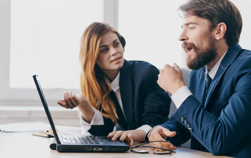 Деловой мужчина и женщина перед ноутбуком, офисная работа, коллеги, профессионалы