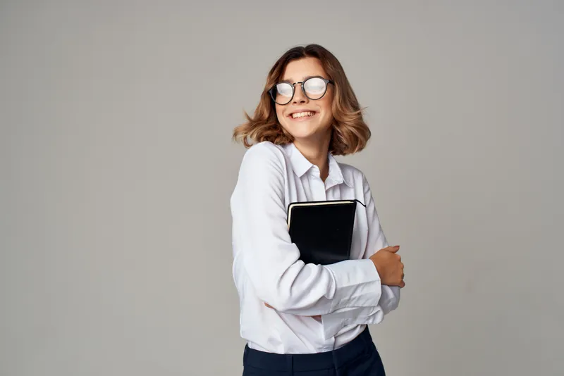 Женщина в костюме с документами в руках работает на светлом фоне