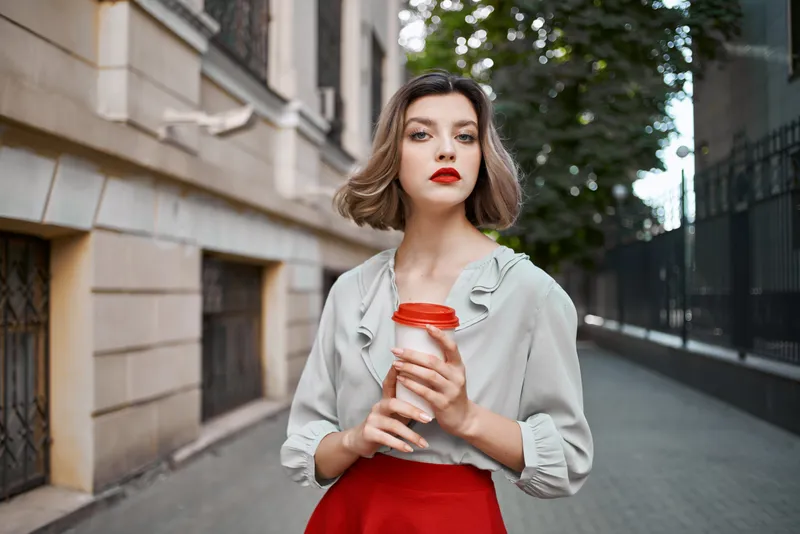 Женщина на открытом воздухе с чашкой кофе прогуливается, отдыхая летом