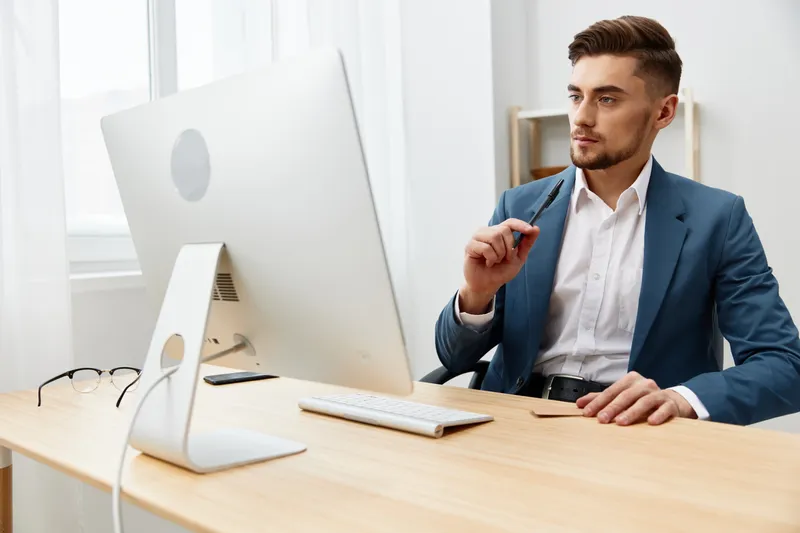 Бизнесмены в очках работают за компьютером на офисном рабочем месте