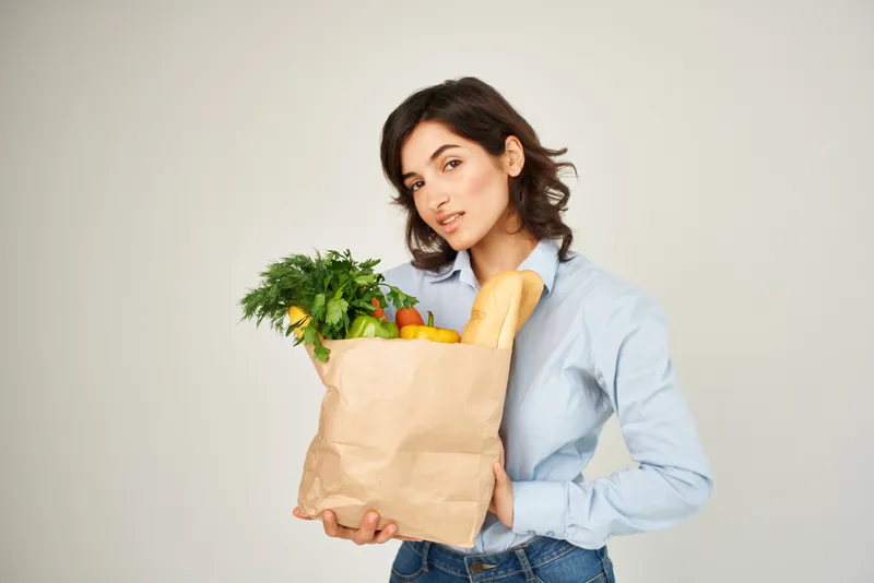 Симпатичная брюнетка с пакетом органических продуктов, овощи, здоровье