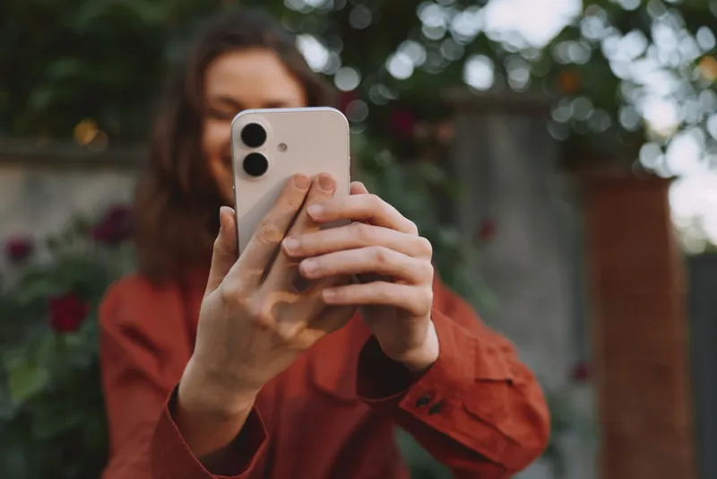 Young woman in a casual jacket takes a spontaneous outdoor selfie, capturing a candid everyday moment with a friendly vibe and natural lighting