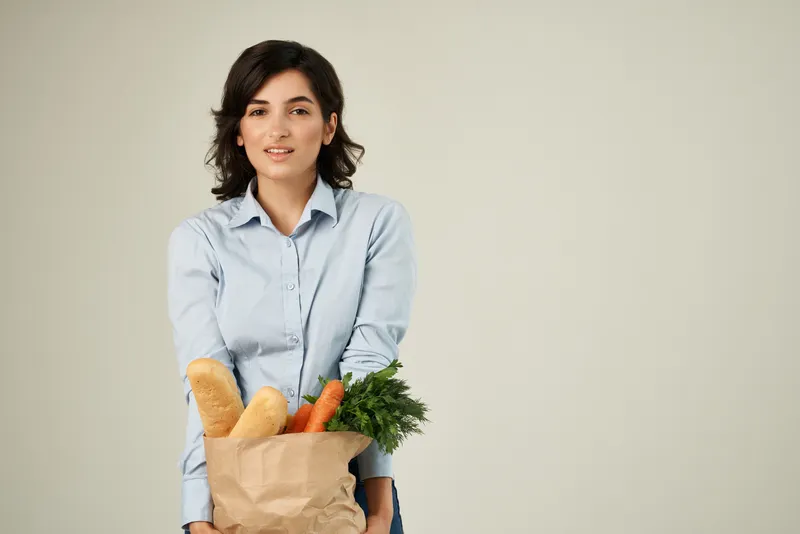 Брюнетка с пакетом продуктов в супермаркете