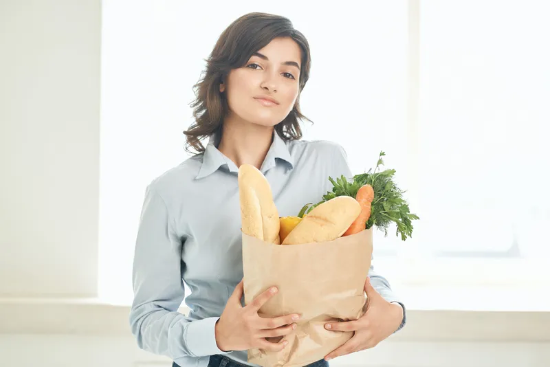 Брюнетка с пакетом продуктов, образ домохозяйки, супермаркет