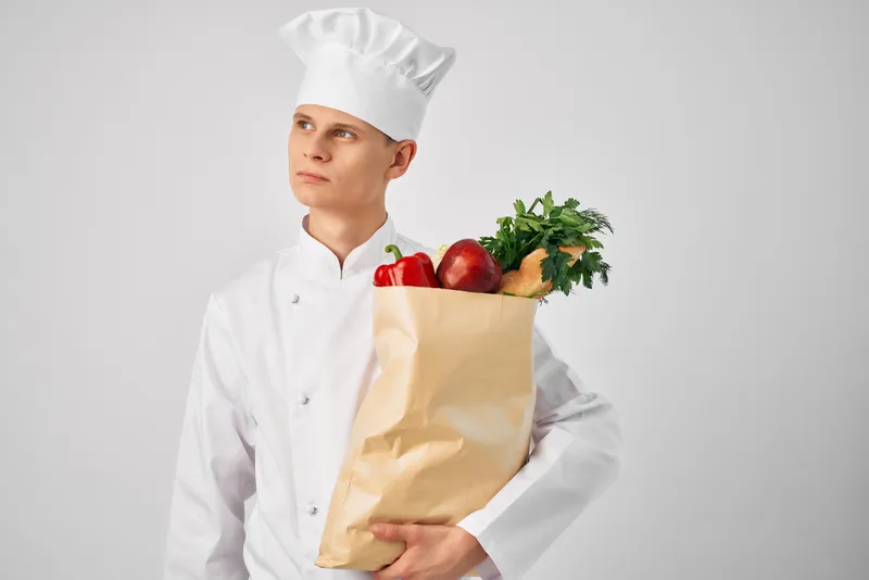 Шеф-повар с упаковкой свежих продуктов занимается приготовлением еды