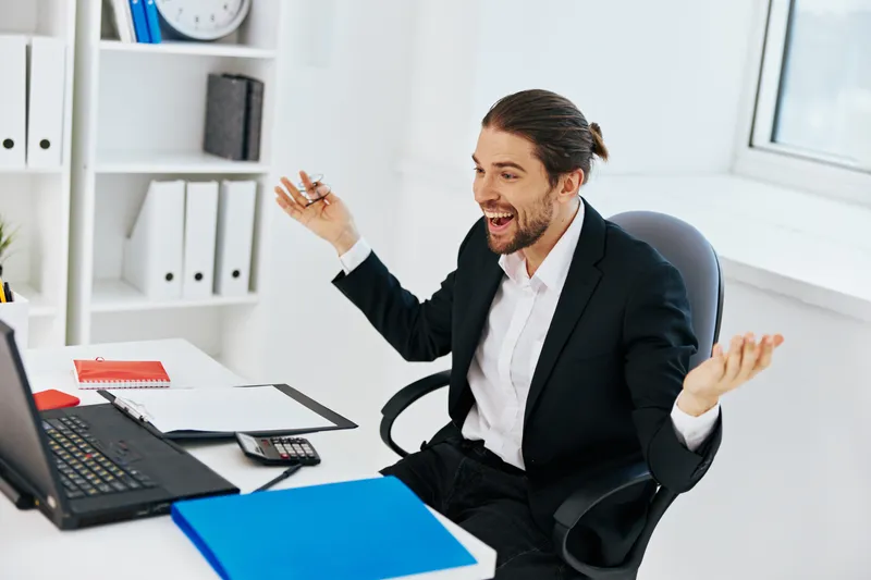 Бизнесмен работает с документами за ноутбуком в офисе