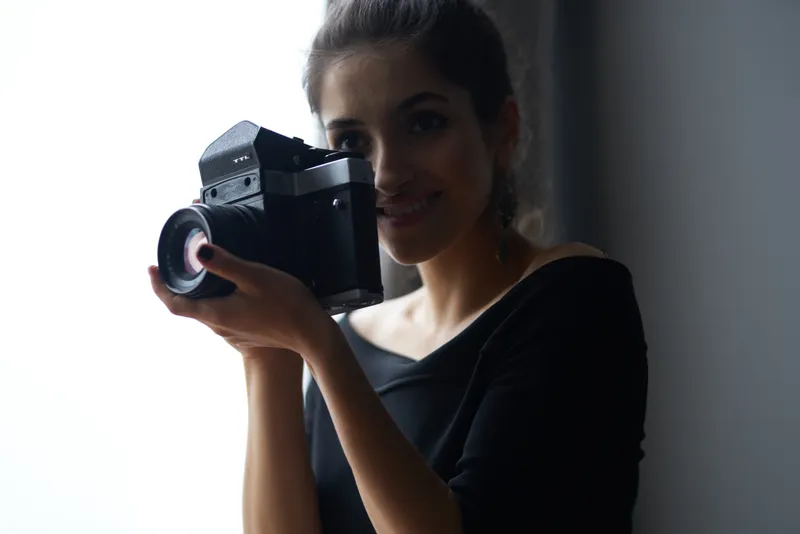 Счастливая женщина-фотограф в помещении, силуэт, модель в вечернем платье