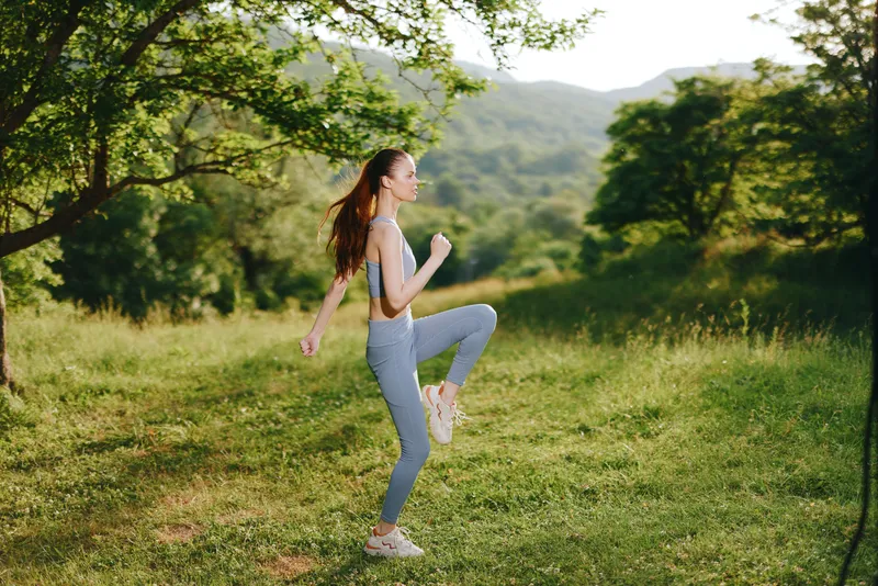 Young woman jogging in a green meadow, showcasing healthy lifestyle and fitness Emphasizing movement, nature, and vitality with a serene background