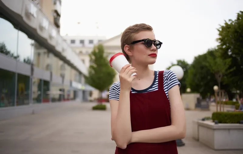 Модная женщина в сарафане и очках на лице