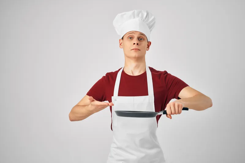 Мужчина-повар, кухонная утварь, профессиональная кухня, ресторан на светлом фоне
